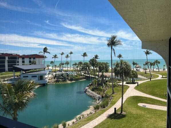 A resort with a pool, palm trees, and a view of the ocean. - Pointe Santo B35 on Sanibel Island. Lovely view of the beach and the pool. (Sanibel Island)