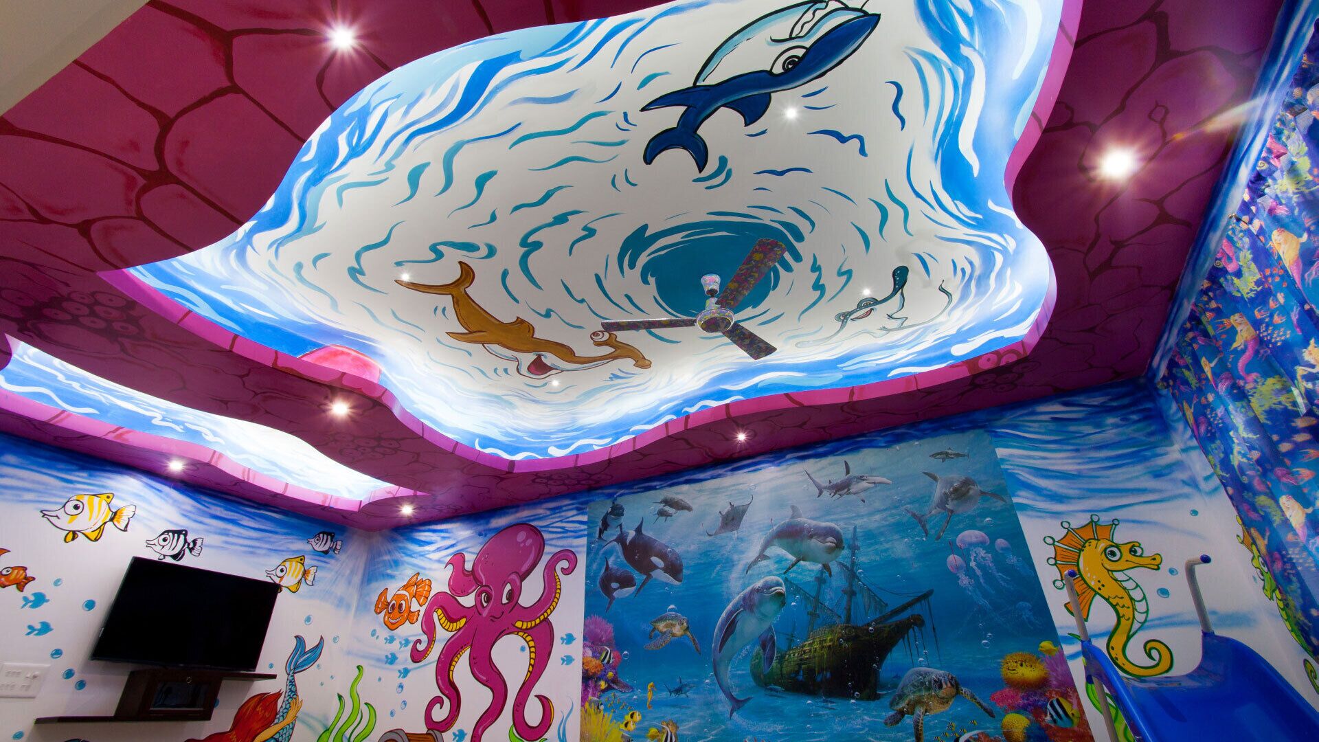 A vibrant underwater-themed mural with a large whale, dolphins, and various sea creatures.
