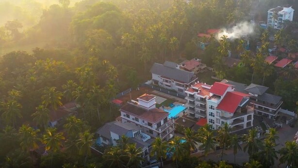 A resort with multiple buildings, including a large structure with a red roof and several smaller buildings with white roofs.