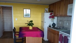 Una cucina compatta con un tavolo da pranzo, sedie, un frigorifero e un forno a microonde.