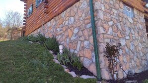 A stone building with a wooden exterior and a grassy slope. - Secluded Cabin on the Hill in the Hocking Hills (Laurelville)