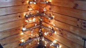 A wooden ceiling with a string of lights and star-shaped decorations. - Secluded Cabin on the Hill in the Hocking Hills (Laurelville)