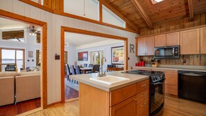 Una cocina amplia con armarios de madera, un microondas y un fregadero.