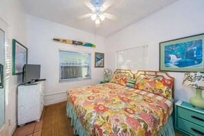 A bedroom with a bed, a ceiling fan, a window with blinds, a dresser, and a painting on the wall. - Su Casa - Beachfront Home - Indian Rocks Beach (Indian Rocks Beach)