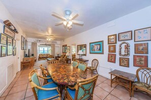 A dining area with a large table, chairs, and a ceiling fan. - Su Casa - Beachfront Home - Indian Rocks Beach (Indian Rocks Beach)