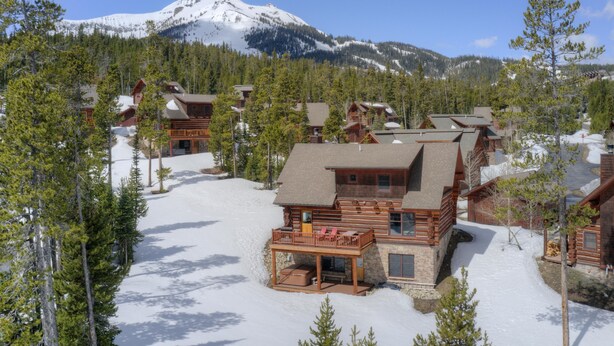 A lodge with multiple cabins, a ski slope, and a snow-covered mountain in the background. - Ski-In/Ski-Out Powder Ridge Cabin In Beautiful Big Sky (Big Sky)