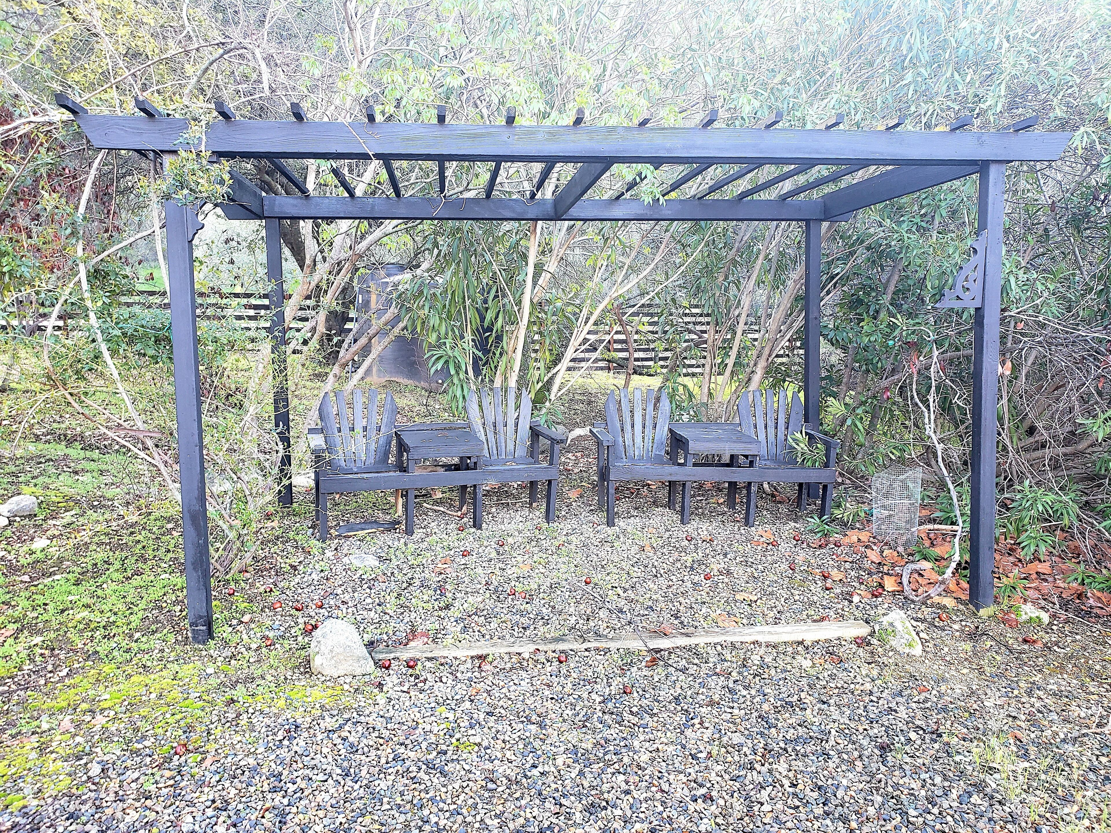 Eine Hollaube mit zwei Adirondack-Stühlen.