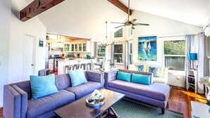 A spacious living room with a gray sectional sofa, a coffee table, and a ceiling fan.