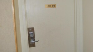 A door with a keypad lock and a sign above it.