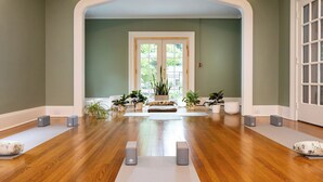 A spacious room with wooden flooring, a large arched doorway, and several potted plants. - Prepare to fall in love with this adorably tropical beach front property! (Kingsville)