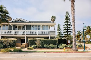 A two-story building with a balcony, a fire hydrant, and a street lamp.