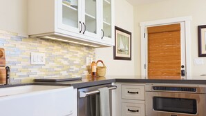 A kitchen with white cabinetry, a built-in oven, and a tiled backsplash.