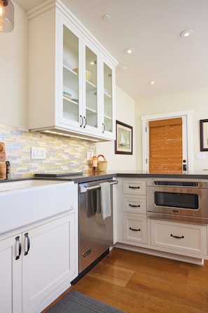 A kitchen with white cabinetry, a built-in oven, and a tiled backsplash.