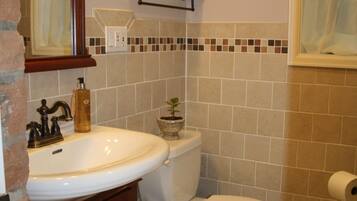 Ein Badezimmer mit Waschbecken, Toilette und Spiegel.