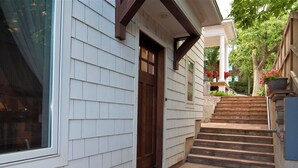 A house with a front porch, a wooden door, and a set of stairs leading to the entrance. - Luxury Homebase in Downtown Boulder  (Boulder)