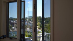Une chambre avec vue sur un port de plaisance et sur des collines.
