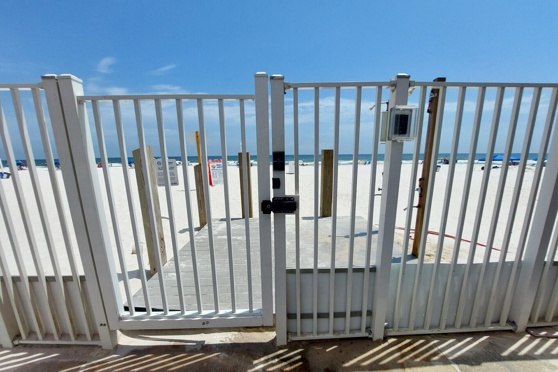 A gated beach area with a clear view of the ocean and beach.