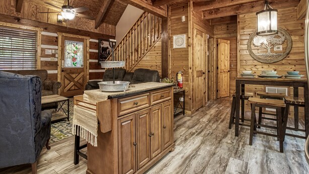 Ein Holzblockhaus-Innenraum mit Essbereich, Küche und Wohnzimmer.