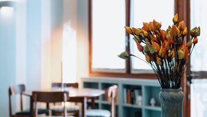 Un jarrón con flores en una habitación con una mesa y sillas.