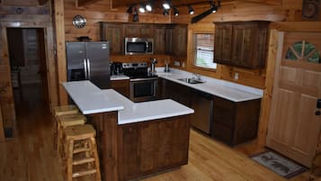 A kitchen with wooden cabinets, stainless steel appliances, and a white countertop.