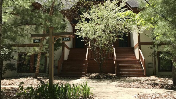 Un bâtiment doté d’un escalier en bois menant à une porte portant le numéro 592.