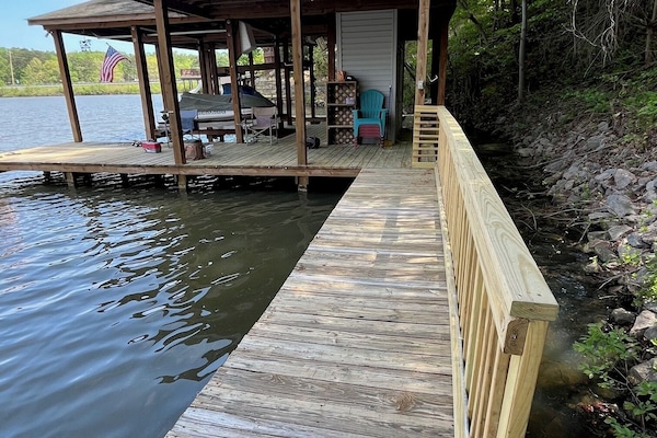 Walkway to private boathouse with swim ladder and boat lift.