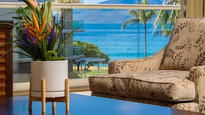 A room with a view of the ocean, a potted plant, a sofa, and a table. - Oceanfront Views Above Dukes - Wrap Around Lanai - Outdoor Kitchen 🌺 Honua Kai H351 (Lahaina)