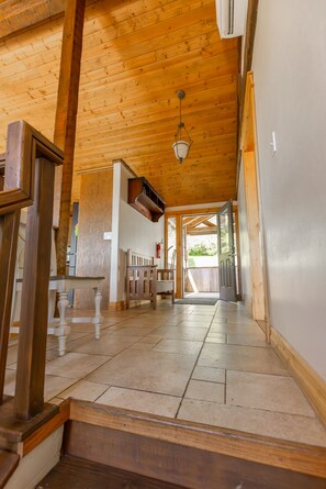 A wooden interior with a staircase, a hallway, and a door leading outside. - Headland- Oceanfront Family Friendly (Gold Beach)