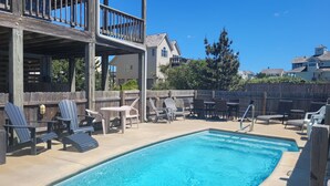 Un espace piscine avec des chaises longues et une terrasse en bois.