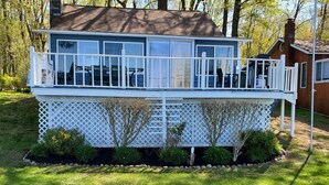 A two-story house with a balcony and a fenced deck area. - Heaven Can't Wait, On Beautiful Kinderhook Lake!! (Valatie)