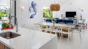 A modern kitchen with a white marble countertop, a built-in dishwasher, and a large island with seating. - Second Chances: Spacious Villa w/Pool, Near Beach (Leeward Settlement)