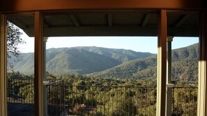 Uma varanda com vista para uma paisagem montanhosa.