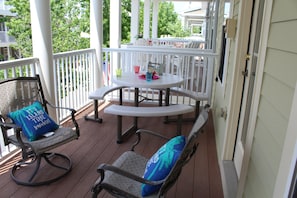 A covered porch with a round table and two rocking chairs, each with a blue pillow. -  Bay views, 5 BR - family friendly 4 level luxury townhouse, Sunset Island  (Ocean City)