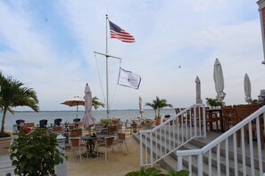 A beachfront restaurant with outdoor seating, a flagpole with an American flag, and a view of the sea. -  Bay views, 5 BR - family friendly 4 level luxury townhouse, Sunset Island  (Ocean City)