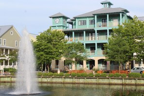 Stunning clock tower building with balconies and a serene fountain in a quiet residential area.