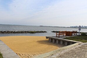 Overlooking the ocean, this serene beach offers a wooden bench and a small platform.