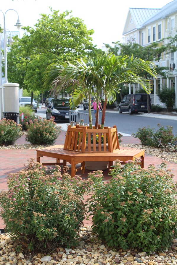 Situated in a serene landscaped area, this bench offers a peaceful retreat amidst lush greenery and decorative elements.