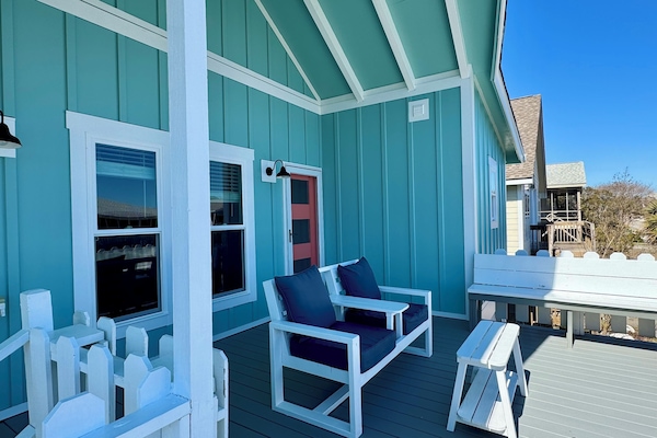 Oversized front porch with painted deck, loveseat, bench seats, & sliding gate