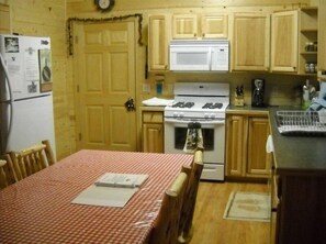 Enjoy cooking in this well-equipped kitchen with a central stove, microwave, and coffee maker.
