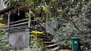 A rustic wooden staircase leading to a porch with a view of a forested area. - Cozy Mount Gretna Chautauqua Cottage near Hershey with treehouse porch  (Mount Gretna)