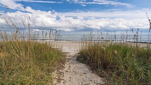 A sandy beach path with tall grasses leading to the sea under a partly cloudy sky. - 4BR/4Bth Direct Oceanfront,House,Covered Porch and fireplace! (Edisto Beach)