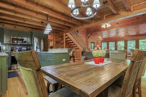 A wooden cabin interior with a kitchen, dining area, and a staircase. - Rockin' River by Mountain Oasis | Trout Fishing Cabin Coosawattee (Ellijay)