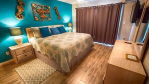 Ein Schlafzimmer mit Bett, Nachttischen, einem Schminktisch und Wanddekoration.