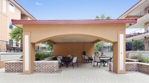An outdoor patio area with brick planters, tables, and chairs.