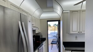 A compact kitchen with white cabinets, a stainless steel refrigerator, and a Bosch dishwasher. - Beautiful Sunsets On White Sandy Beach , Great Heated Pool - (Marco Island)