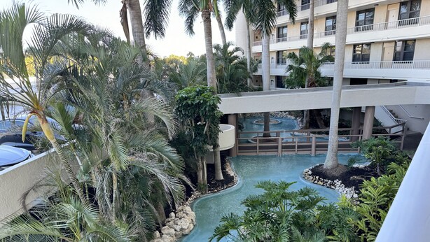 A hotel with a pool surrounded by tropical plants and palm trees. - Beautiful Sunsets On White Sandy Beach , Great Heated Pool - (Marco Island)