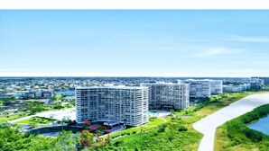 A modern residential area with high-rise buildings, a river, and green spaces. - Beautiful Sunsets On White Sandy Beach , Great Heated Pool - (Marco Island)