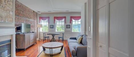 Un salon moderne avec une cheminée, un coin repas et un canapé.