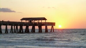 A pier extending into the sea with a covered structure at the end. - Twin Palms Cottage (Tybee Island)