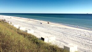 A beach with a clear sky, sandy shore, and a few people walking. - Spectacular Ocean View! Great Location On 30A   King Bed ,Newly Remodeled! (Santa Rosa Beach)